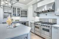 The stainless steel hood is the perfect complement to this light, bright, and white kitchen.