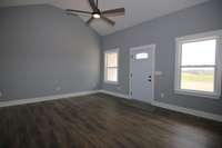 The main living area is open and has a ceiling fan and vaulted ceiling. The living area is an open floor plan.