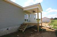 Covered back deck with ceiling fan over looking a nice size back yard.