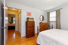 Another view of the bedroom with beautiful, original hardwood floors.