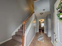 Entry foyer with tile flooring and custom staircase.