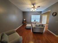 Cozy living room with hardwood flooring and door to patio area.