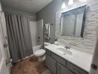 Second full bath with tile flooring and custom back splash.