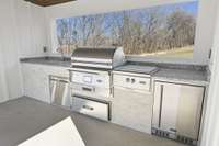 Full Outdoor Kitchen nestled in the Cabana w/window opening views of the right side of the property. Coyote Pellet Grill, Natural Gas Power Burner, Refrigerator, Sink, Ice Chest, Trash&Storage Drawers