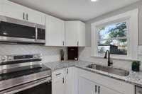 Herring Bone tile back splash, custom cabinets, stainless appliance package, deep stainless sink