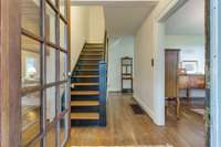 Beautiful entryway from the front porch. Original hardwood floors and solid staircase.