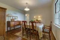 Formal dining room right off the entrance with views across the front porch and entry to the kitchen.