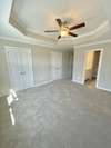 The primary bedroom features crown molding with his & her closets!