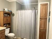 guest bathroom with tub shower combo. extra linen storage