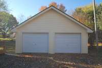 Oversized detached 2-car garage has double doors, concrete floors and an office space.