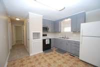 Fresh painted cabinets with built in microwave, under cabinet lighting, stove and refrigerator to remain.