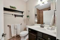 Bath 2 Features a Large Raised Vanity, Decorative Shelving & a Roll-in Ceramic Tile Shower & Floor. 