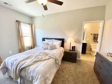 Master bedroom on main level with attached full bath and walk-in closet (photo is of model home with same floor plan)