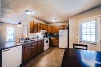 Nice size kitchen. All kitchen appliances remain. Shows the back door area. Vinyl flooring in the kitchen.