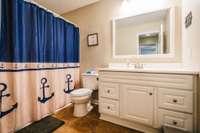 Guest bath with nice size vanity. Lament flooring in baths.