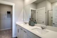 Dual sinks with quartz countertops in owner's bath. Nice walk in closet