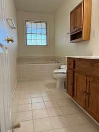 Hall bath with ceramic tile and a garden jetted tub