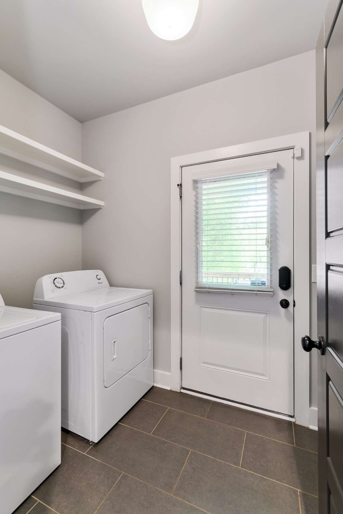 The laundry room is ready to go! Washer/Dryer Remain. Built-in shelving and a drop zone behind the door.