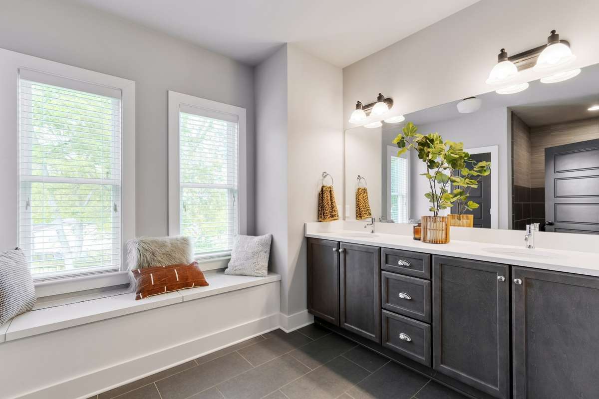 Downstairs Primary Suite with double vanities and a built-in bench, which opens for extra storage.