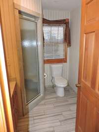 This full bathroom is located off the eat in kitchen, with the large laundry/storage room just down the hall.