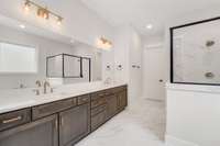 Primary bathroom with double vanities , stand alone tub and tile shower.