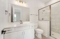 Guest bath with quartz countertop, tiled shower