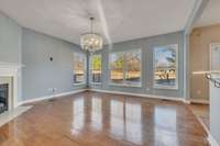 Living room with corner fireplace open to the kitchen and has fabulous view to the yard