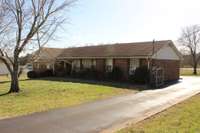 Paved driveway with gated and fenced back yard parking.