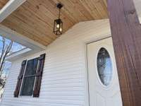 A rocking chair front porch is inviting and a nice place. Stunning wood details are warm and welcoming.