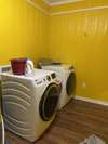 Utility room sits between the kitchen and the covered back deck. It includes this new washer and dryer.