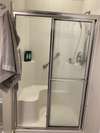 Walk-in shower with built-in shower seat for safety.