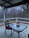 Covered back deck winter view of neighboring property with large pond. Ample room for dining outside and entertaining.