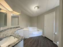 Master bath with granite counter tops, soaking tub, and shower.