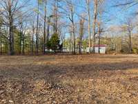 Back of the home from the middle of the property. So much room for a new home. Live in the trailer while you build. All clear for you to build