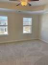 The primary bedroom features a trey ceiling with crown molding