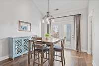 spacious dining room has updated light fixture and french doors to patio