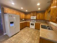 The kitchen features lots of cabinets and counter tops, stove, microwave, DW, refrigerator, can lights and window to watch the deer in the back yard. Previous owner said you could feed them out of your hands