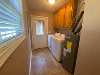 Closer look at the cabinets and tile floors in this nice size utility room. Door off the side of the house with porch