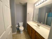 The guest bath has lots of counter top space, cabinets and tile floors