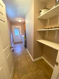 The Utility Room has shelves for pantry off the kitchen, cabinets over the washer and dryer area