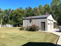 Side view of detached garage. Also 2 sheds and fenced area for animals (pervious owner used it as a kennel