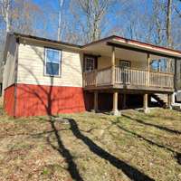 Low maintenance yard and a rocking chair covered front porch. Brand new gutters, tin roof, and beautiful trees!