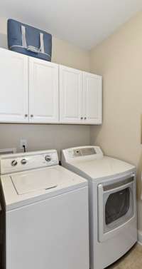 The laundry room has cabinets for extra storage.