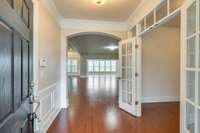 What a captivating entrance!  The extra wide arched doorway if the perfect presentation for what lies ahead.  To the right is a separate office area with a glass transom and French doors.