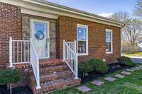 Cute front porch with storm door and detailed stone accent.