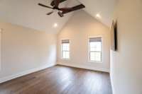 Master bedroom downstairs with vaulted ceilings, custom black out shades, hardwood floors, & dream bathroom. 