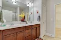 Primary bathroom with double vanities, linen closet.