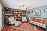 Living area with finished hardwood floors and built ins.  Exit from living room to back yard with covered patio and pool.