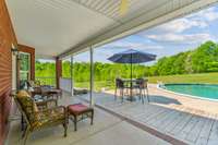 Covered porch and deck over looking pool and large back yard.