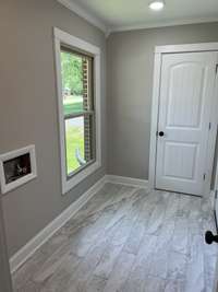 Utility Room with access to half bath and door to carport - waterproof luxury vinyl